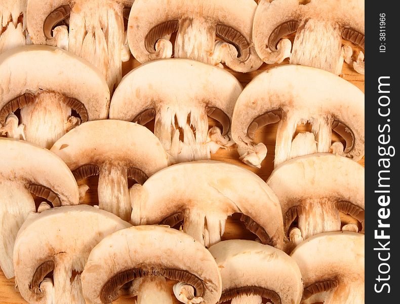 Sliced mushrooms on a wooden chopping board