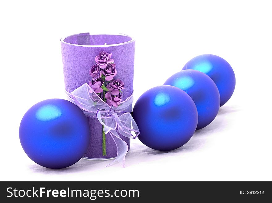 A purple candle with christmas balls isolated on white background. A purple candle with christmas balls isolated on white background.