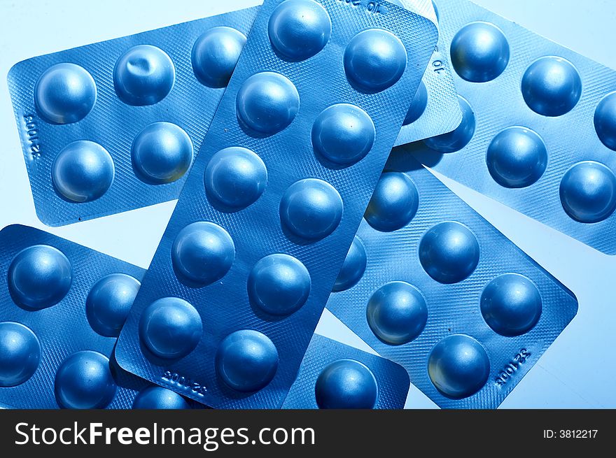 Blue pills on blue background