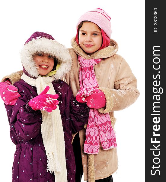 Two elementary girls bundled in winterwear giving each other hugs. Two elementary girls bundled in winterwear giving each other hugs.