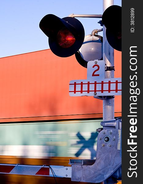 A train crossing with a fast train moving by in the background. A train crossing with a fast train moving by in the background.