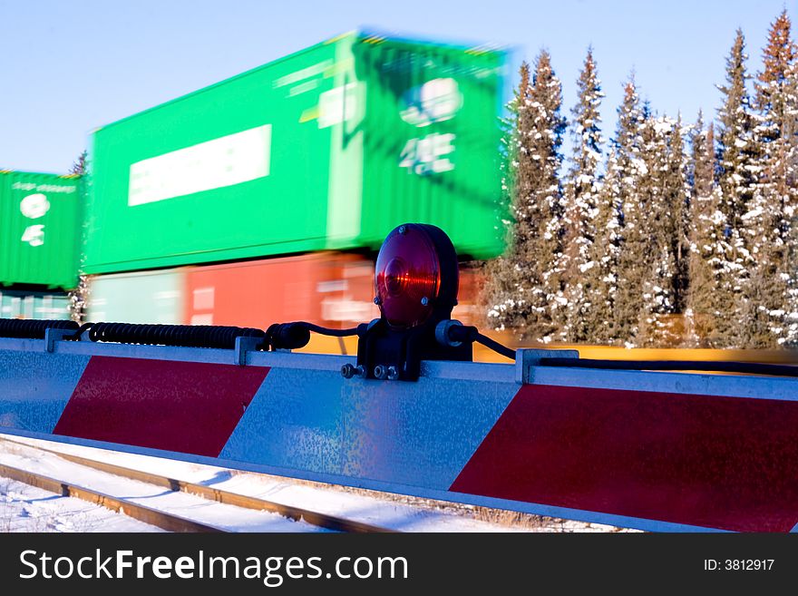 A train crossing with a fast train moving by in the background. A train crossing with a fast train moving by in the background.