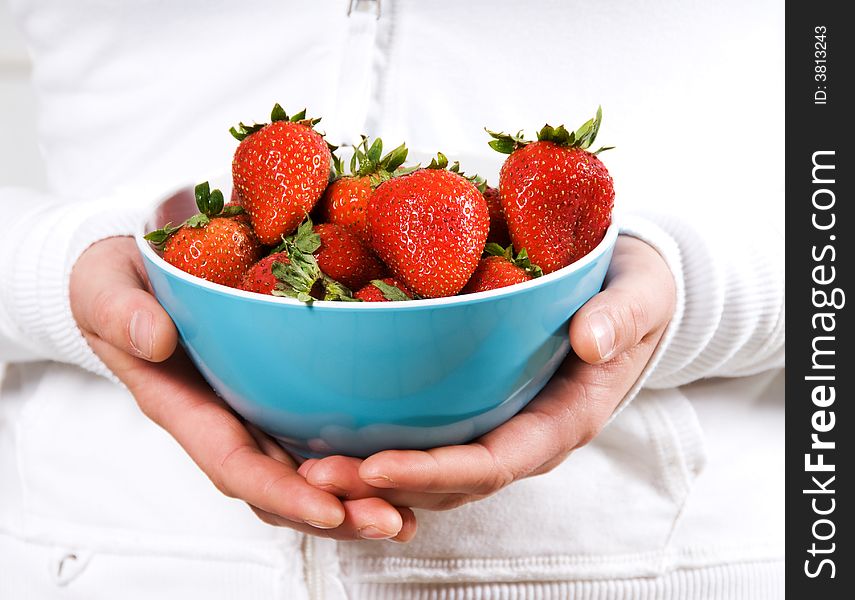 Blue bowl of strawberries fruit in red