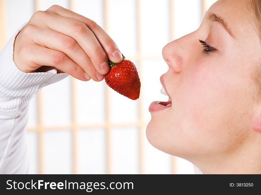 Young woman eating a strawberry for health. Young woman eating a strawberry for health