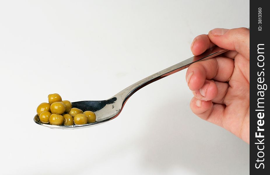 Fresh raw green peas on stainless serving spoon, on white. Fresh raw green peas on stainless serving spoon, on white
