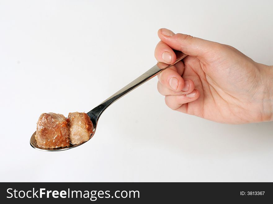 Fried meat on stainless serving spoon, on white. Fried meat on stainless serving spoon, on white