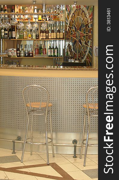 Modern bar kafe-bistro. Bar made of wood, stone and glass. Metal chairs.