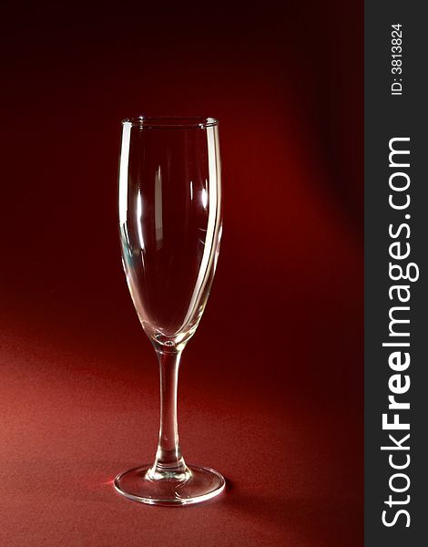 Single champagne glass on red background