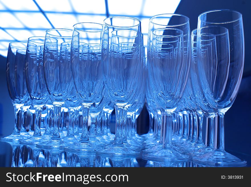 Bunch of empty champagne glasses at party, blue tones.
