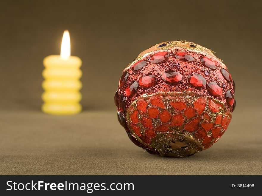 Christmas ball and candle on velvet background