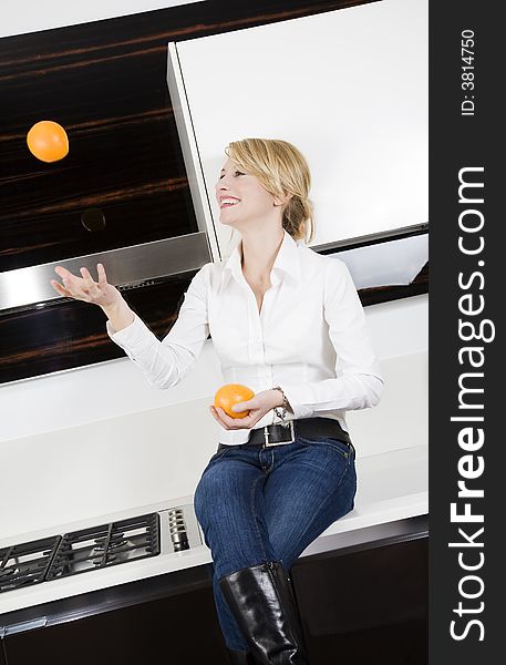 Home life: woman relaxing and playing with oranges