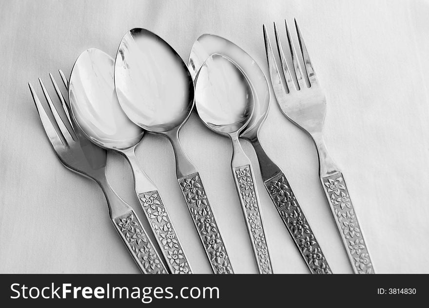 Stainless steel spoons and forks on a table