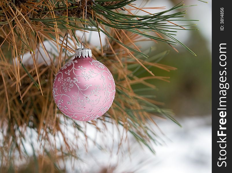 Pink and Silver Christmas Ornament in a snowy pine tree