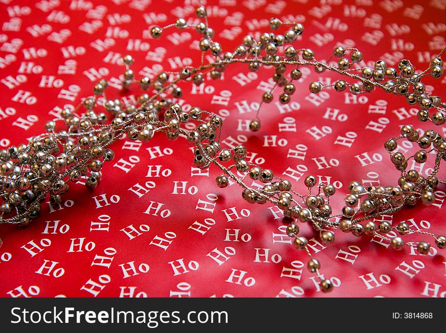 Red Christmas Wrapping paper with ho ho ho on it and silver garland beads