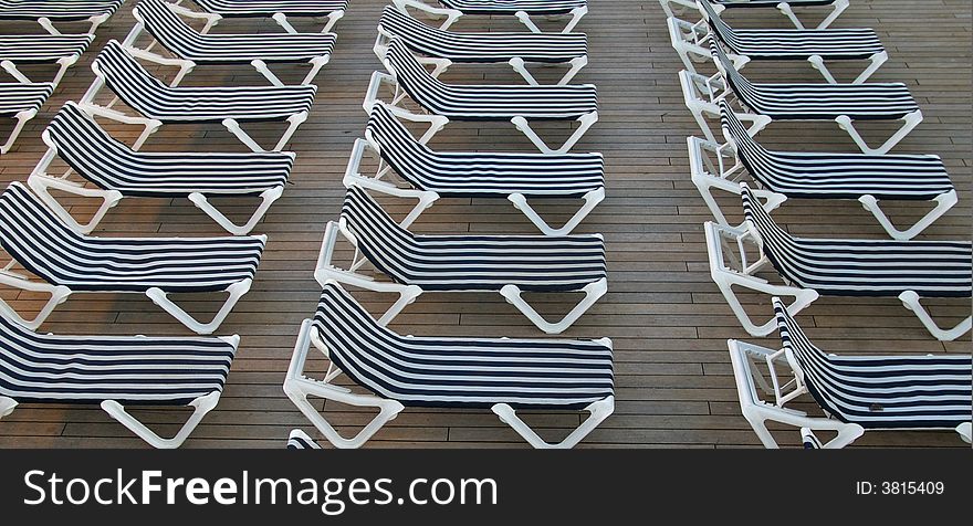 Chairs lined up and ready for the sunbathers on the deck of a cruise ship. Chairs lined up and ready for the sunbathers on the deck of a cruise ship.