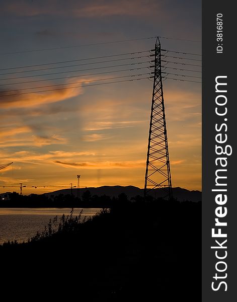 The sunset with clouds behing power lines and pole. The sunset with clouds behing power lines and pole