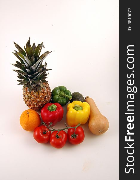 Pineapple and Vegetables on a white background, A collection of fruit and vegetables.Botanically speaking, a fruit is a seed-bearing structure that develops from the ovary of a flowering plant, whereas vegetables are all other plant parts, such as roots, leaves and stems. This includes such botanical fruits as eggplants, bell peppers and tomatoes. Pineapple and Vegetables on a white background, A collection of fruit and vegetables.Botanically speaking, a fruit is a seed-bearing structure that develops from the ovary of a flowering plant, whereas vegetables are all other plant parts, such as roots, leaves and stems. This includes such botanical fruits as eggplants, bell peppers and tomatoes