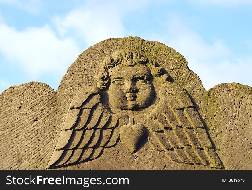 Old ancient Angels Face against blue sky