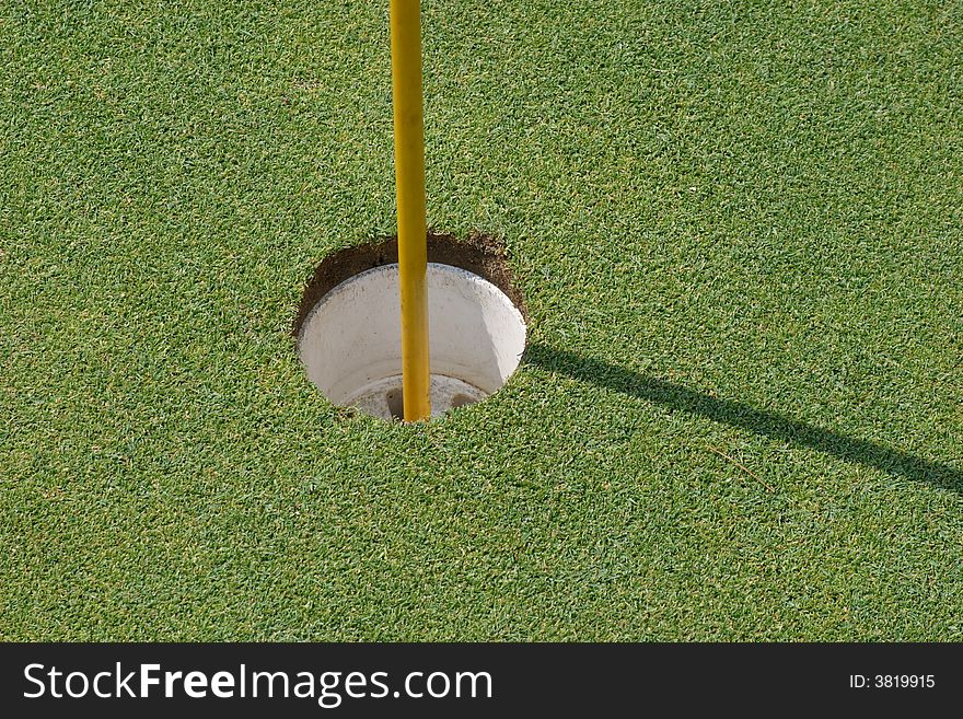 Empty putting hole with flag stick. Empty putting hole with flag stick