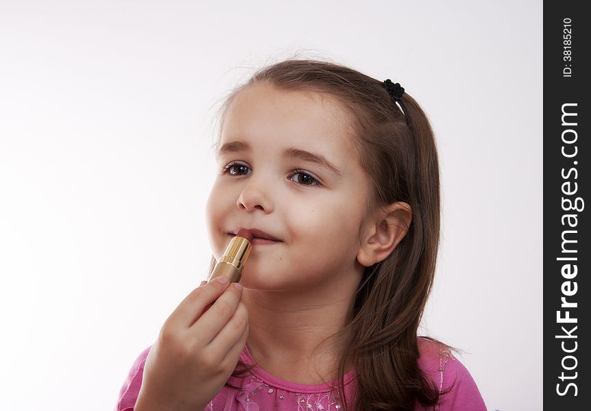 Cheerful girl in pink blouse paints lips. Cheerful girl in pink blouse paints lips