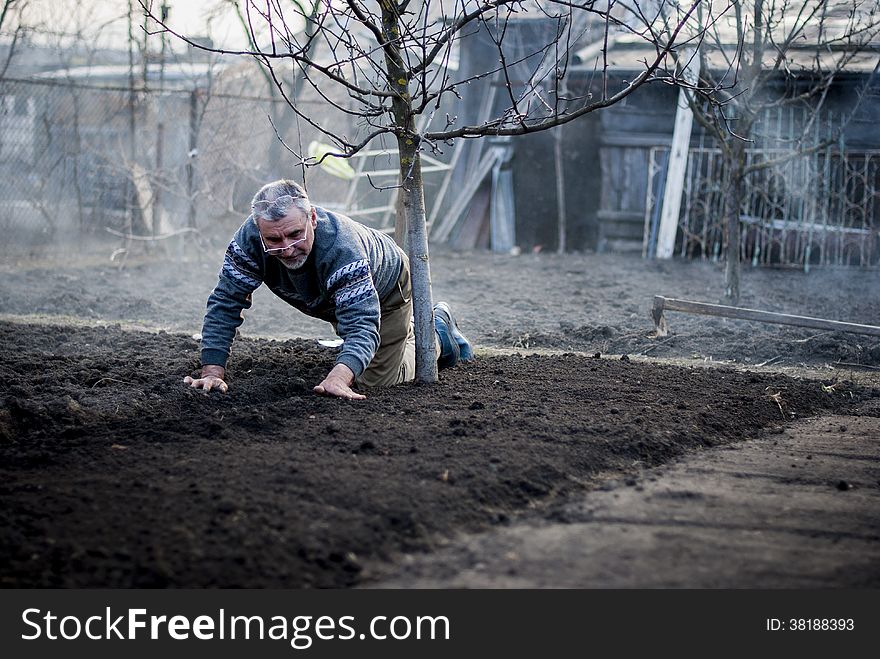 Old romanian man working his land in a traditional way with empty hands and having 2 pairs of glasses. Old romanian man working his land in a traditional way with empty hands and having 2 pairs of glasses