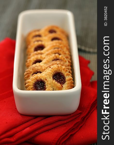 A plate of raspberry pretzel cookies with a red napkin