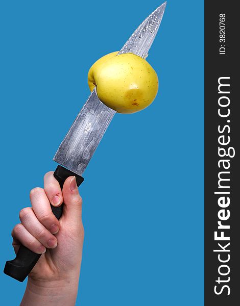 Yellow apple impaled by knife on blue background. Yellow apple impaled by knife on blue background.