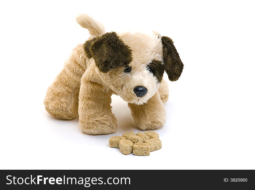 Toy puppy eating food on white background