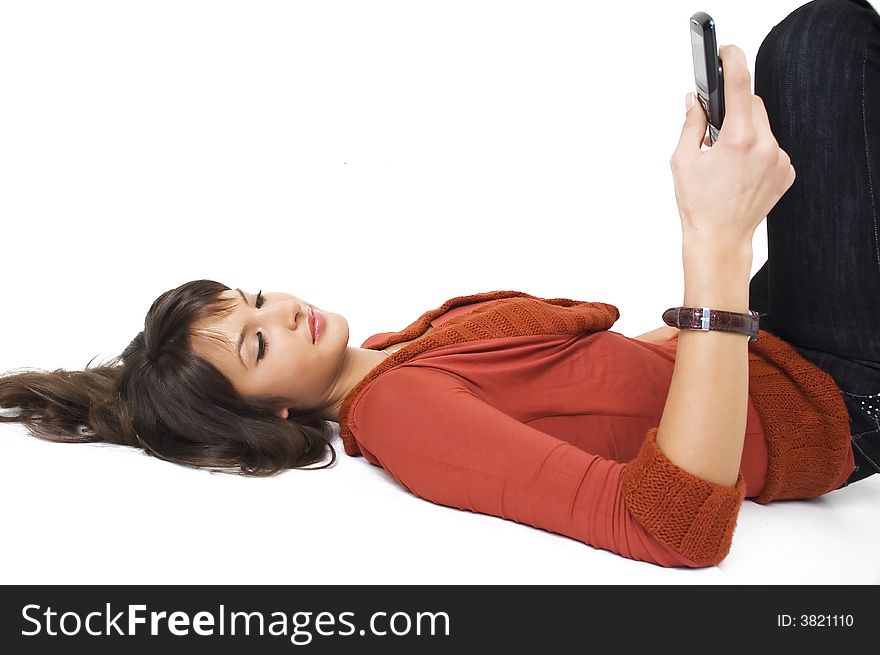 Young brunette girl with mobile phone on white background.