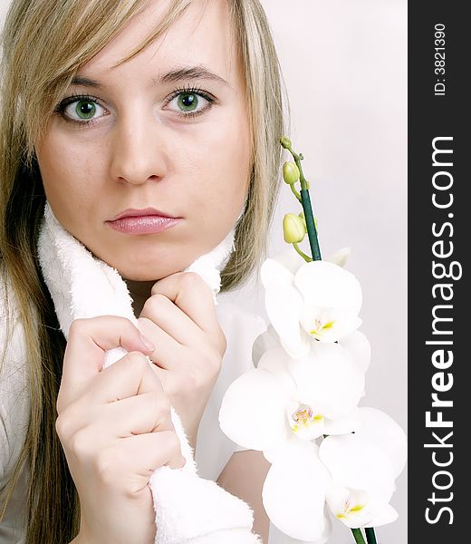 Close up of beautiful woman with white towel on the neck and white orchid. Close up of beautiful woman with white towel on the neck and white orchid