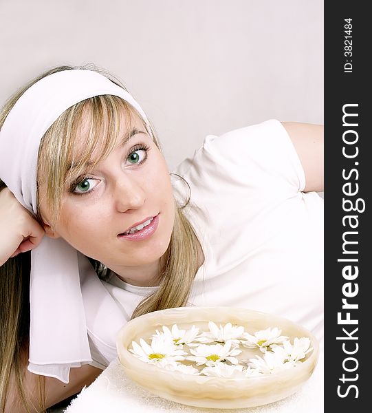 Close up of beautiful woman and bowl with water and daisies. Close up of beautiful woman and bowl with water and daisies