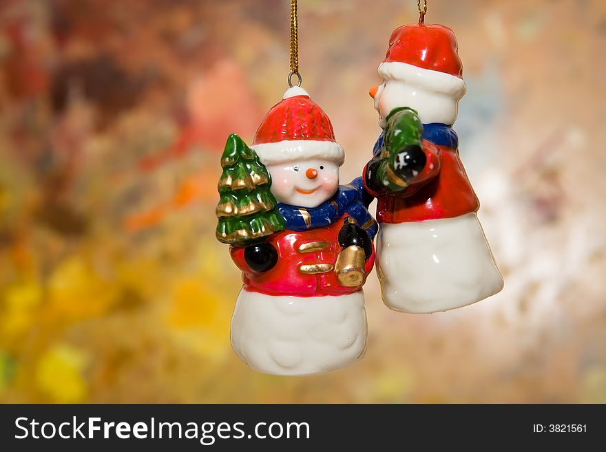 Snowman toys hanging against colorful background. Snowman toys hanging against colorful background.