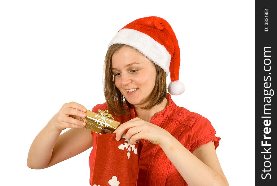 Young girl with cute smile and santa hat looking at her christmas gift in golden wrap. Young girl with cute smile and santa hat looking at her christmas gift in golden wrap