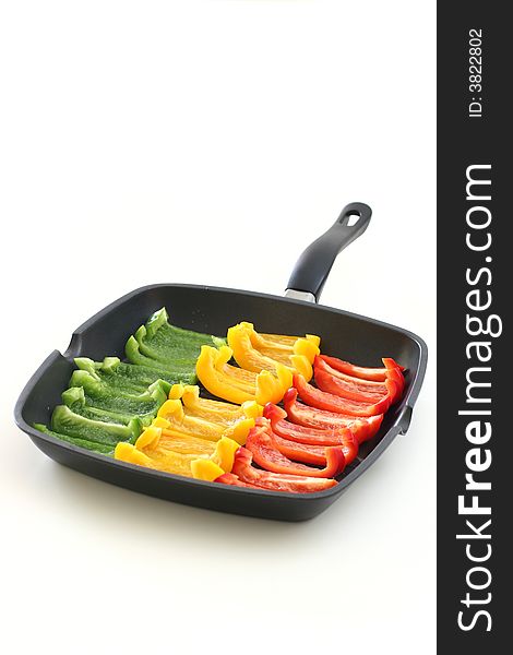 Colorful rows of green, yellow and red capsicum strips prepared for cooking on a pan. Colorful rows of green, yellow and red capsicum strips prepared for cooking on a pan