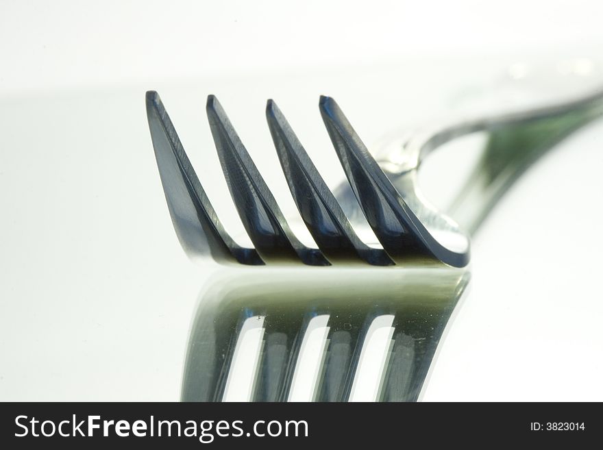Close-up of one fork on a mirror