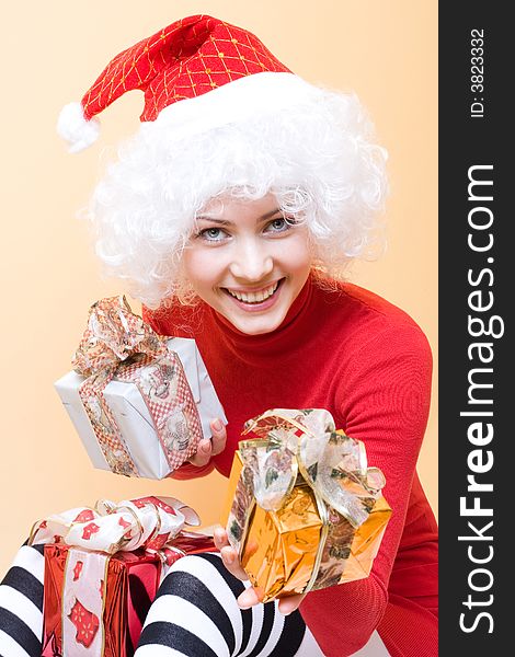 Beautiful young woman wearing santa hat with gifts. Beautiful young woman wearing santa hat with gifts