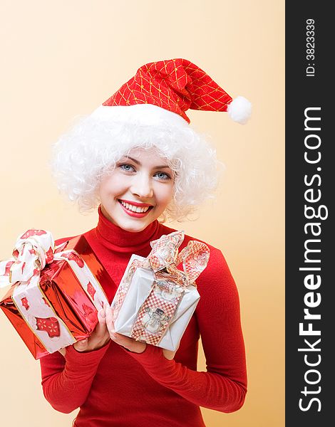 Beautiful young woman wearing santa hat with gifts. Beautiful young woman wearing santa hat with gifts