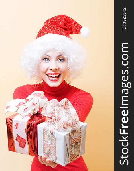 Beautiful cheerful young woman wearing santa hat with gifts. Beautiful cheerful young woman wearing santa hat with gifts