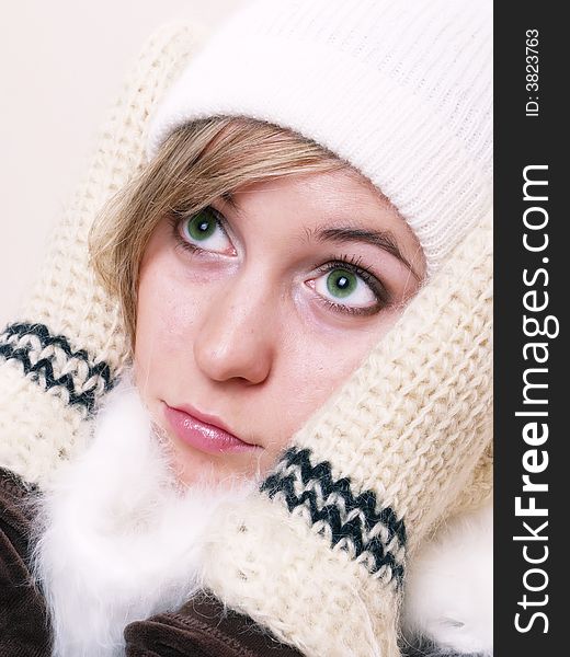Closeup of young beautiful girl, wearing wool winter hat and scarf