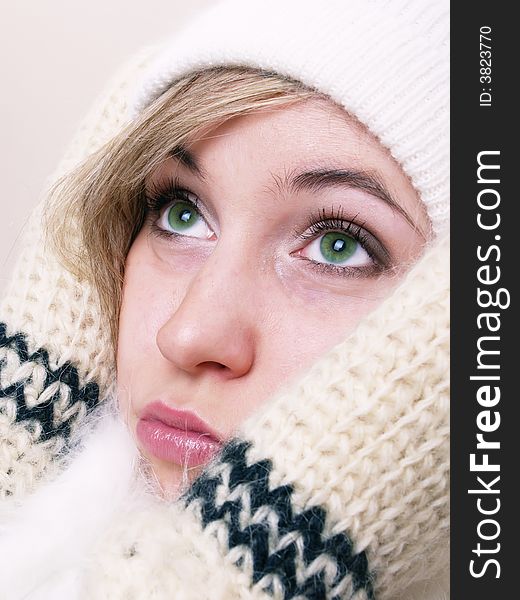 Closeup of young beautiful girl, wearing wool winter hat and scarf