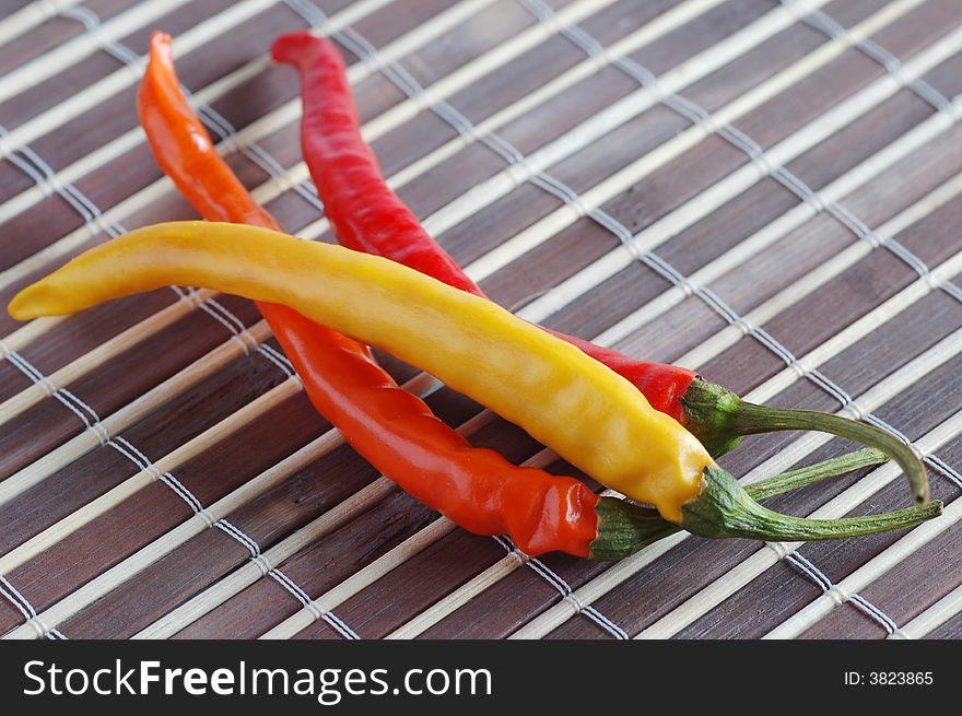 Three chilli pepper on bamboo background