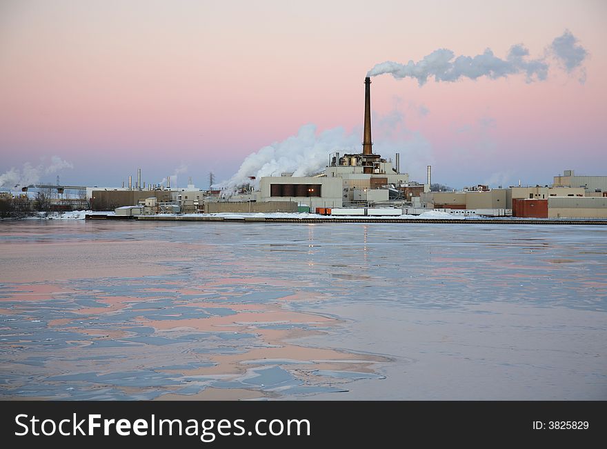Power plant located on an icy river at sunset. Power plant located on an icy river at sunset.