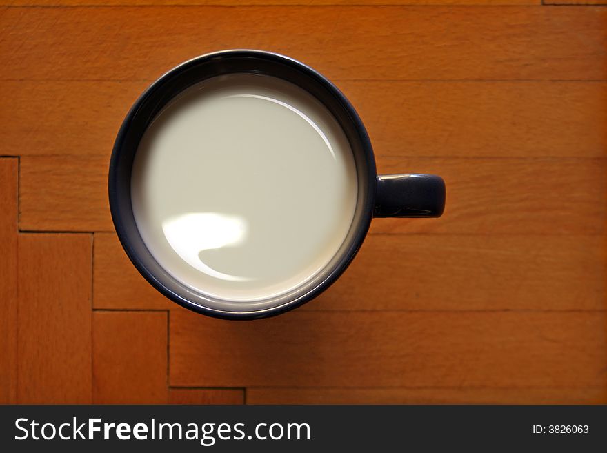 Cup with milk on a wooden background