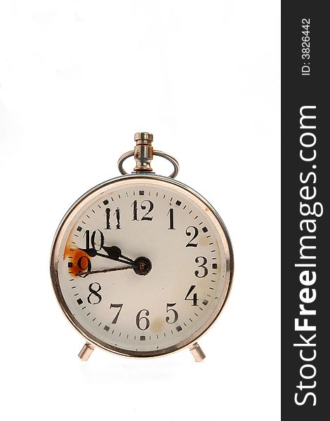 Old alarm clock with a distressed face against a white background