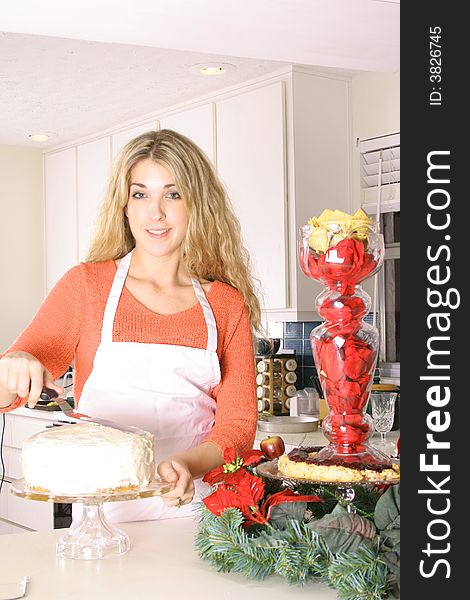 Woman in the kitchen frosting a cake