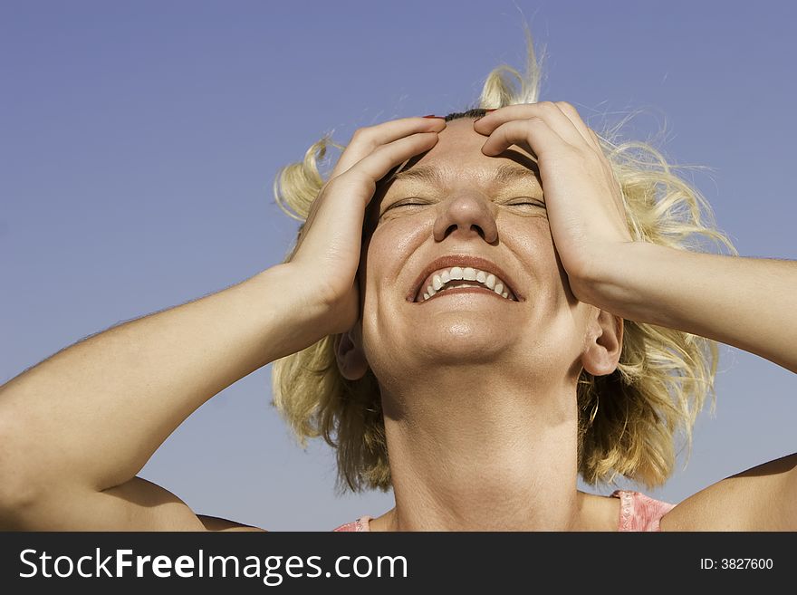 Close-up of a blonde woman outdoors laughing. Close-up of a blonde woman outdoors laughing.