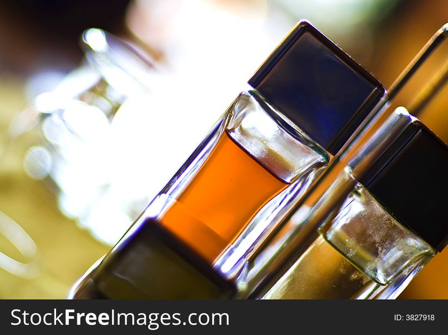 Tilted glass reflection with a bottle of orange liquid.