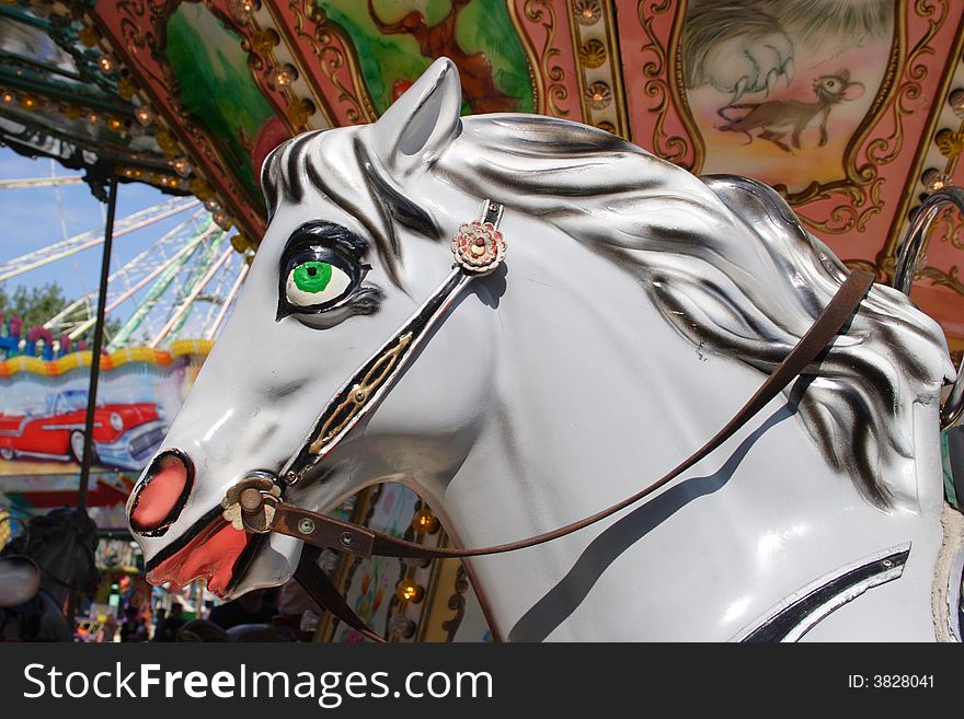 Brightly painted carousel horse bathed in the setting sun