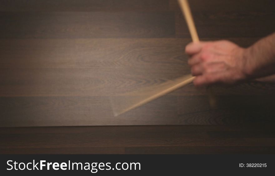 Drummer warming up practicing percussion exercises. HD format, wooden background.