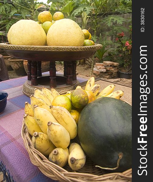 Tropical fruit, banana, watermelon, orange and pomelo, on a table in a garden. Tropical fruit, banana, watermelon, orange and pomelo, on a table in a garden.